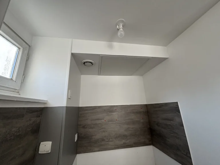 Coin cuisine rénové d’un studio à Lille, plafond et murs repeints après un dégât des eaux