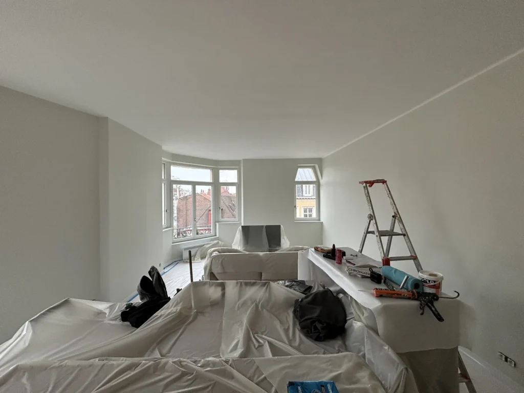Séjour d’un appartement lillois de la rue du Molinel repeint en blanc, bow-window et sols protégés pendant le chantier