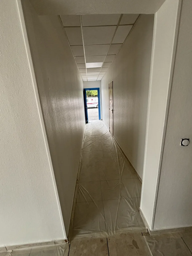Couloir du rez-de-chaussée d’une copropriété à Wasquehal, sols carrelés protégés pendant la mise en peinture