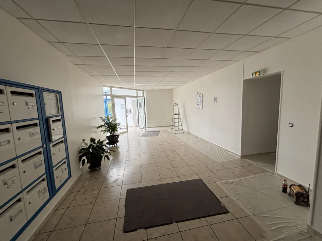 Hall d’entrée d’une copropriété de Wasquehal après rénovation des peintures en blanc cassé