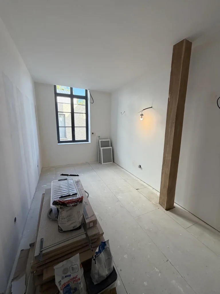 Chambre de l’appartement d’Arras avec poutre en bois apparente et murs préparés avant peinture