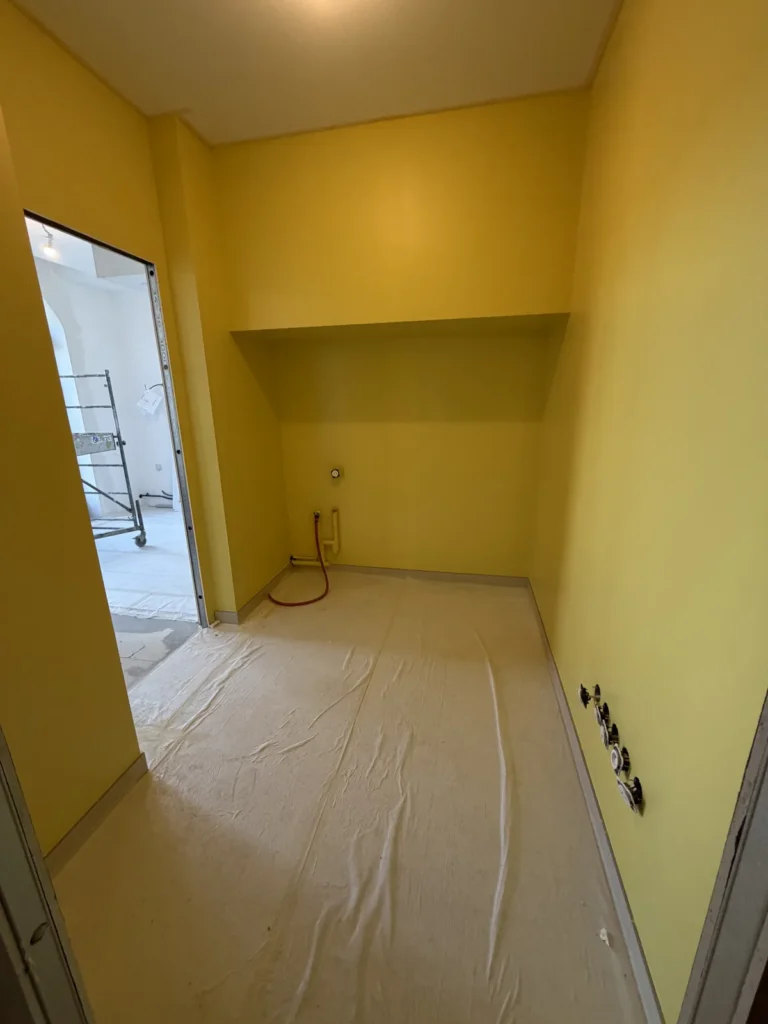 Pièce aux murs peints en jaune soleil dans un appartement neuf à Arras